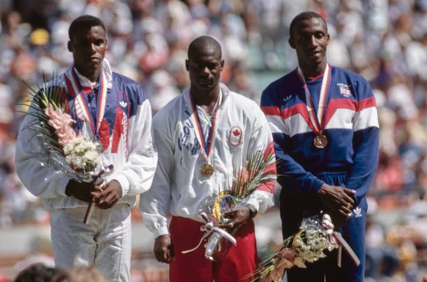 Carl Lewis cùng Ben Johnson và Linford Christie đứng trên bục nhận huy chương tại Olympic