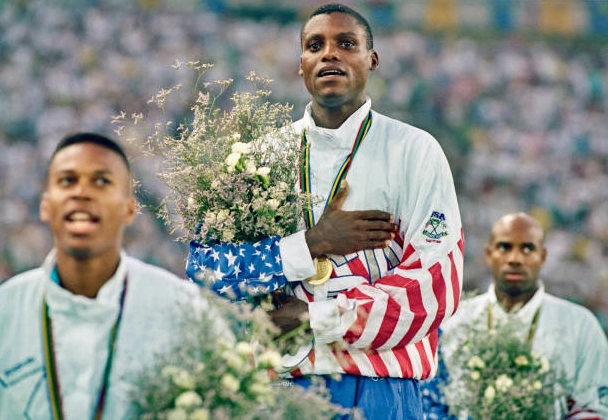 Carl Lewis đứng nghiêm trang trên bục vinh quang và hát vang quốc ca Mỹ sau khi giành huy chương vàng nhảy xa